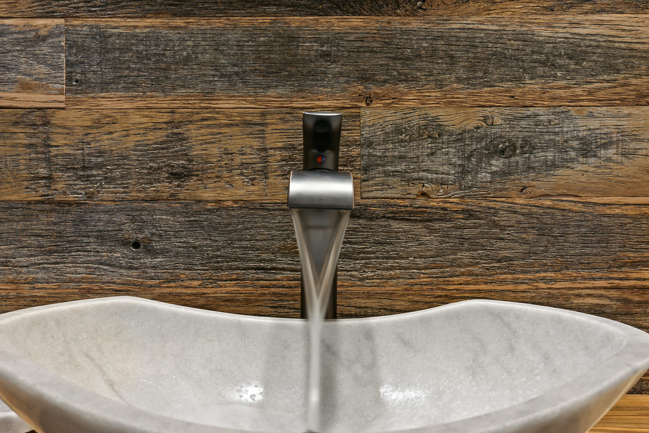 Riverwood bathroom with a wood vanity, vessel sink, and white subway-tile shower