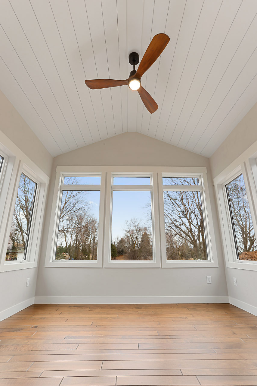 Sunroom with shiplap and ceiling fan with daylight