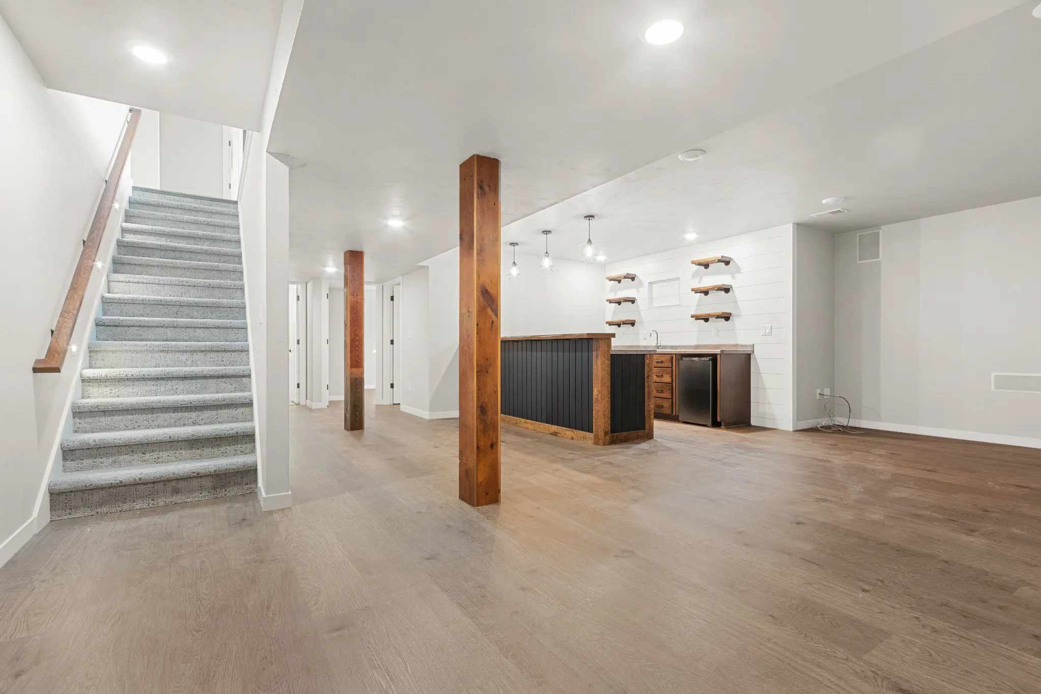 Riverwood basement with wood columns, a black-front bar, and white shiplap